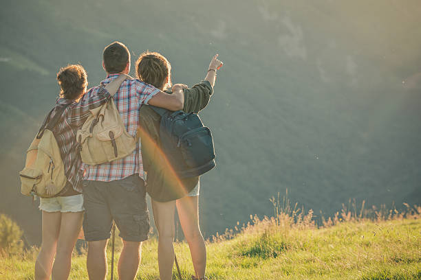 istock Three friends hug themselves looking panorama on mountain at sunset 514178839