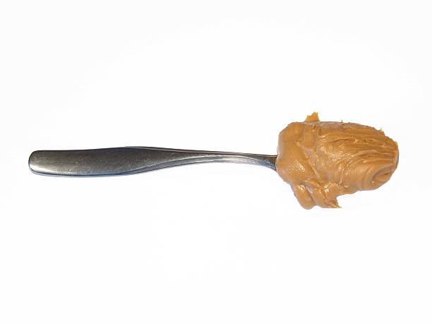 istock Spoonful of peanut butter photo on white. 514211237