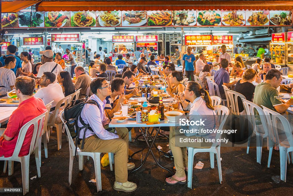 Kuala Lumpur tourists and locals at crowded street cafe Malaysia Kuala Lumpur, Malaysia - 26th June 2014: Crowds of people, tourists and locals, eating and drinking in the al fresco restaurants of Jalan Alor, the popular night market of street food and traditional specialities in the heart of downtown Kuala Lumpur, Malaysia's vibrant capital city. Food Stock Photo