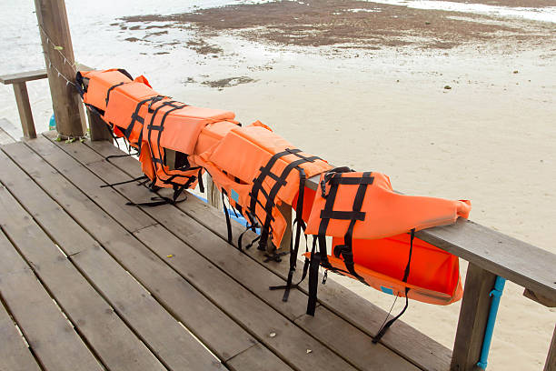 orange coletes salva-vidas na madeira - life jacket equipment safety jacket - fotografias e filmes do acervo