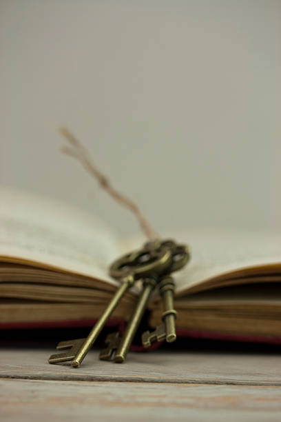 istock Antique keys with book on wooden background 514214320