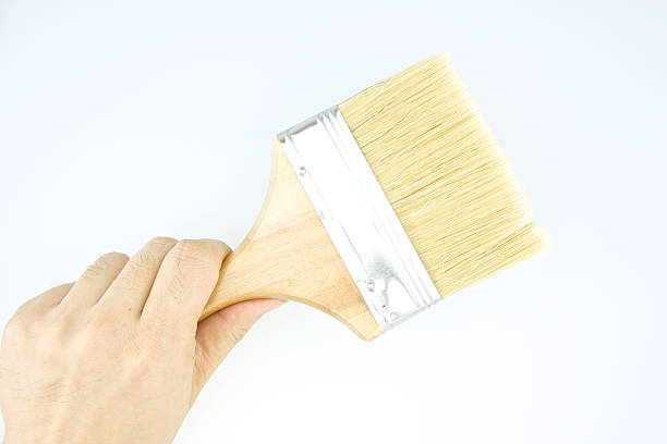 istock Man holding brown paintbrush on corner 514216239