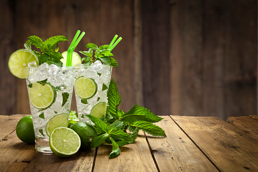 Two mojito cubano drinks on rustic wood table