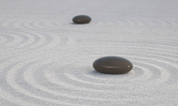Dark Zen stones on white sand stock photo
