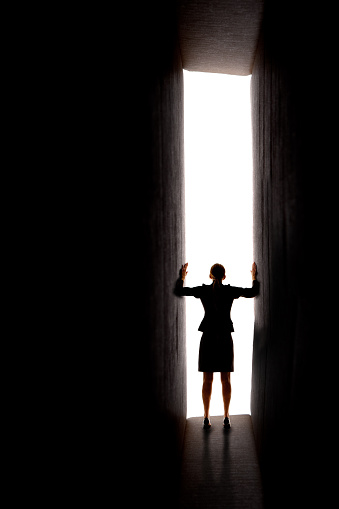 A conceptual image of a buisnes woman opening the doors to opportunity.