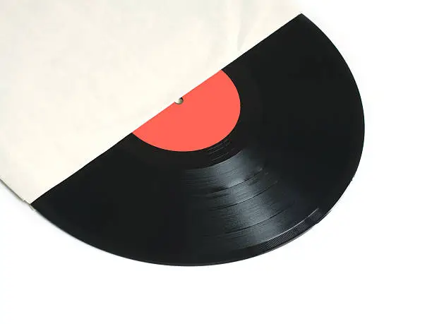 Black long-play vinyl record with red label from the paper sleeve isolated on white background. Photo closeup