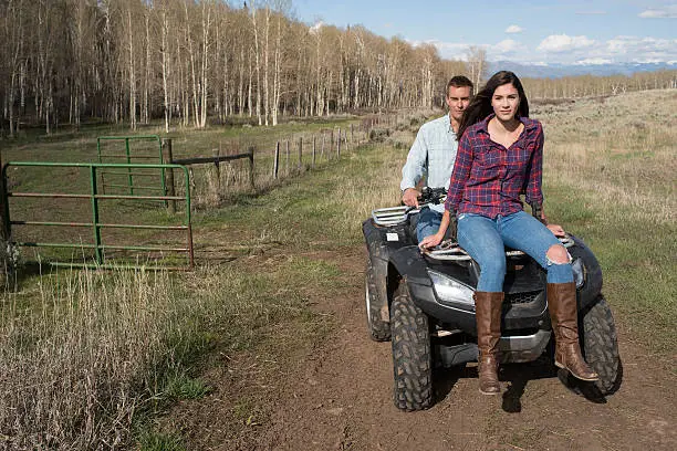 Photo of Young couple on 4 wheeler at a Ranch