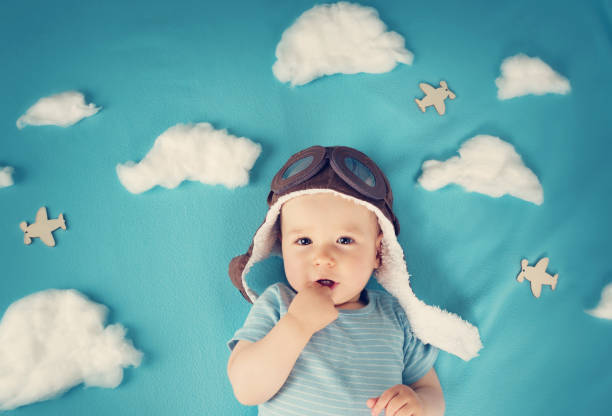 menino deitado em cobertor com nuvens brancas - baby cheerful child blanket - fotografias e filmes do acervo