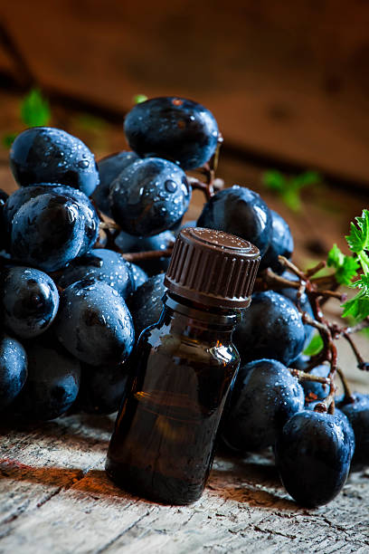 istock Grape seed oil in brown bottle, bunch of grapes, vine 514225892