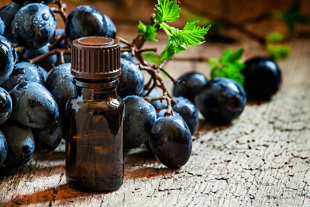 istock Grape seed oil in brown bottle, bunch of grapes, vine 514226094