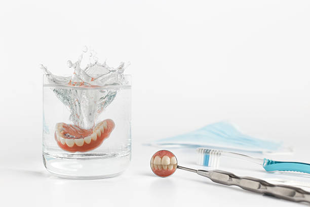 istock Teeth on mirror next to dentures in water 514230868