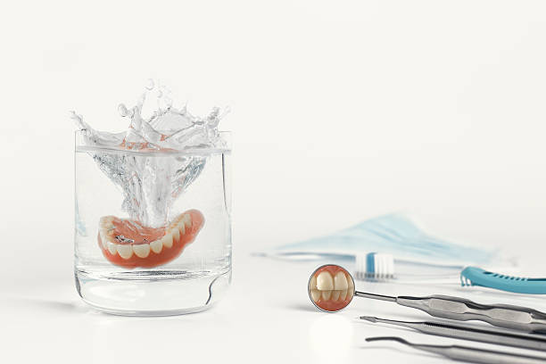 istock Teeth on mirror next to dentures in water 514230886