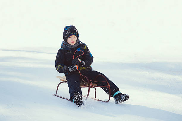 маленький мальчик на сани - little boys sled clothing slide стоковые фото и изображения