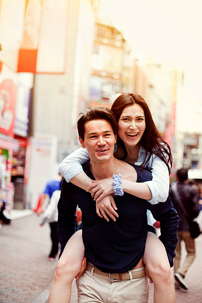 istock Happy young asian couple having fun with piggy back 514235536