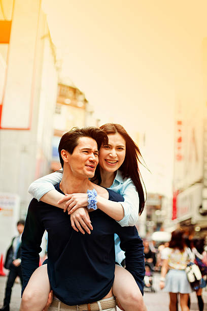 istock Happy young asian couple having fun with piggy back 514235632