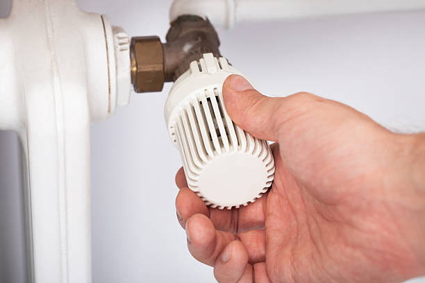 istock Man Adjusting Temperature On Radiator Thermostat 514247545