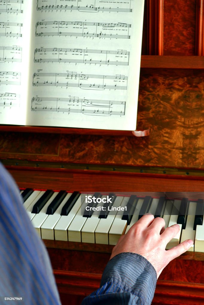 Playing the Piano Caucasian adult male playing an upright Piano, vertical image Adult Stock Photo