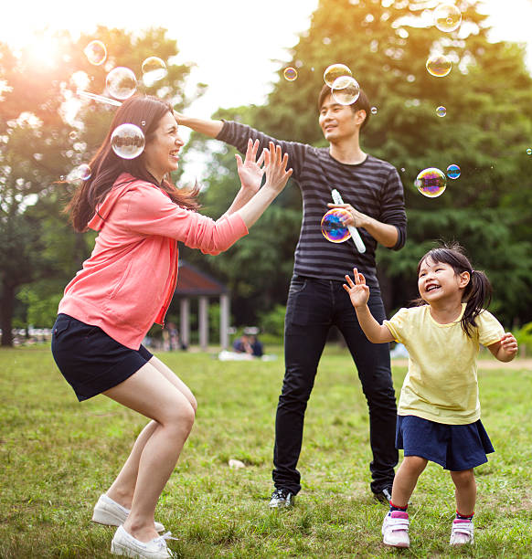 istock Family having fun in park with Soap Bubbles 514259394