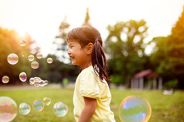 istock Little girl blowing soap bubbles 514259432
