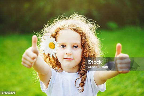 Laughing Girl Showing Thumbs Up Stock Photo - Download Image Now - Thumbs Up, Agreement, Flower