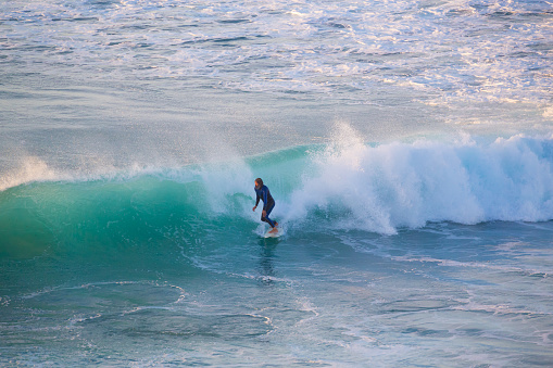 La Pared, Spain - Dec 23, 2015:  Active sporty senior surfer riding perfect wave on La Pared beach, famous surfing destination on Fuerteventura, Canary Islands, Spain on December 23, 2015. 