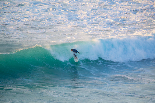 La Pared, Spain - Dec 23, 2015:  Active sporty senior surfer riding perfect wave on La Pared beach, famous surfing destination on Fuerteventura, Canary Islands, Spain on December 23, 2015. 