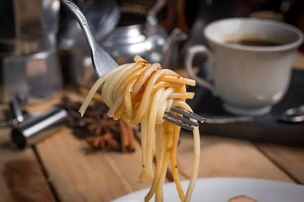 spaghetti with black pepper sauce on wood table