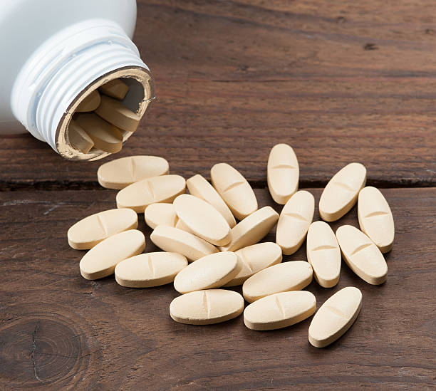 istock yellow bottle with pills on wood 514265498