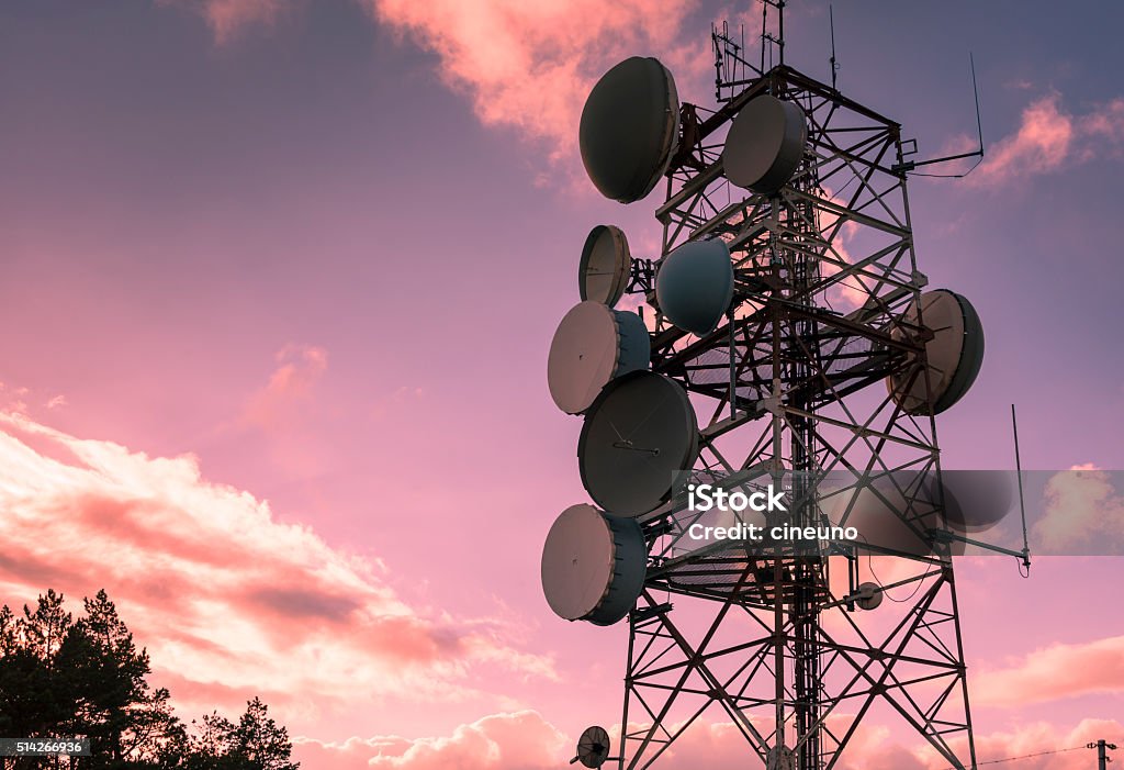 Communication and transmission tower for military use Communication and transmission tower for military use over a magenta sky Communications Tower Stock Photo