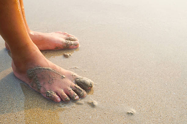 istock Feet of a child on the sand beach 514268672