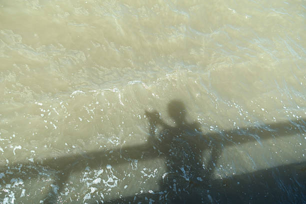 istock shadow of man cast on water 514268891