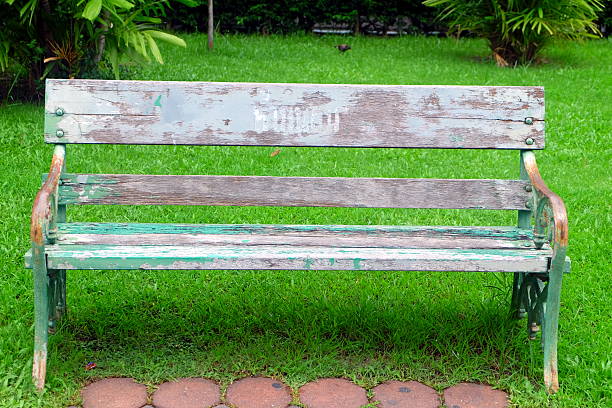 old lonely bench in the park with green grass