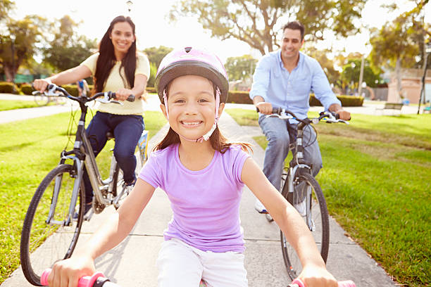 istock Parents With Daughter Riding Bikes In Park 514269615