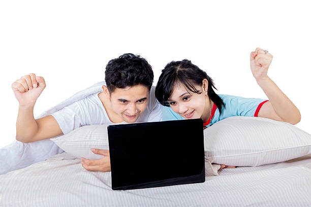 istock Happy couple raise hand on bed - isolated 514269705