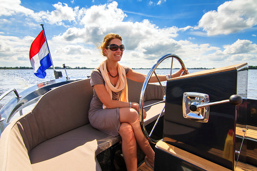 Beautiful lady sailing with a barge/sloop on a sunny summer day in the Netherlands