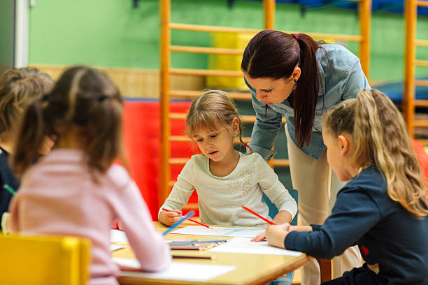 istock Preschool teacher and children in classroom 514270688