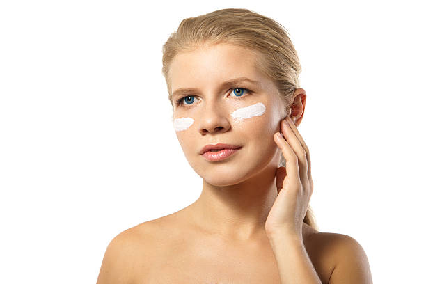 istock Woman applying moisturizer cream on face isolated 514270945