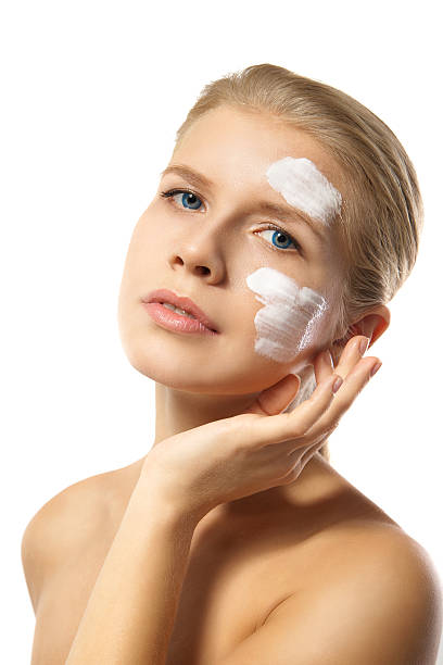 istock Woman applying moisturizer cream on face isolated 514273391