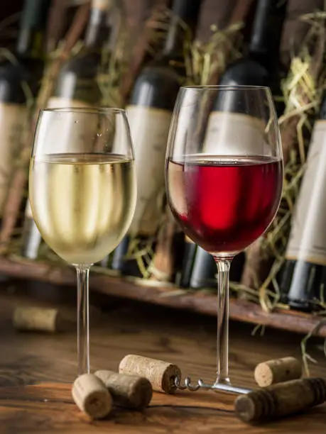 Photo of Wine bottles on the wooden shelf.