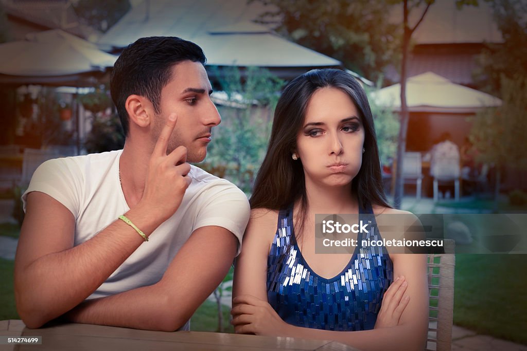 Cute Young Couple Arguing Young adult couple arguing with funny expressions and gestures, out on a date Adult Stock Photo