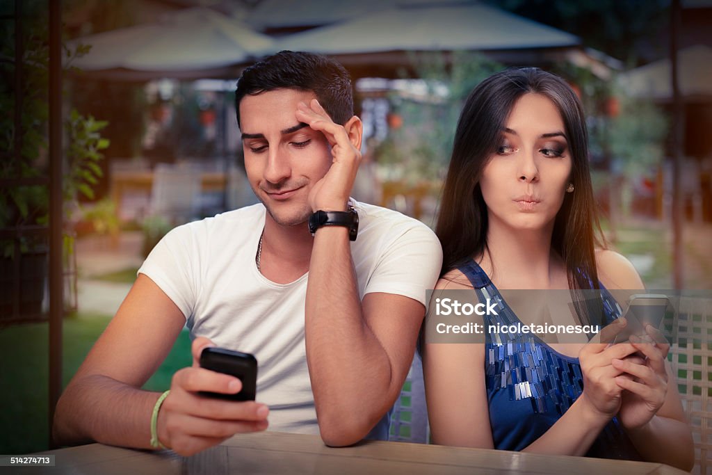 Secretive Couple with Smart Phones in Their Hands Young adult couple has privacy problems with modern technology Couple - Relationship Stock Photo