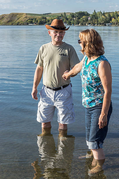 istock man and woman holding hands wading in water 514274931