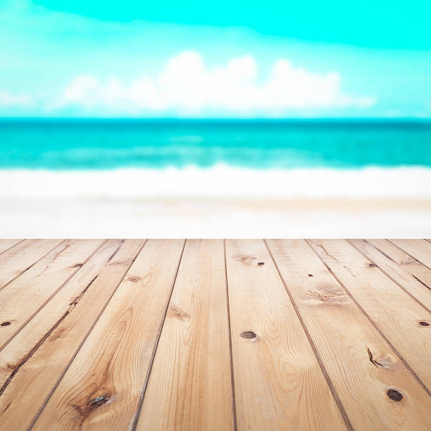 istock Wood table top on blurred blue sea and white sand 514276432