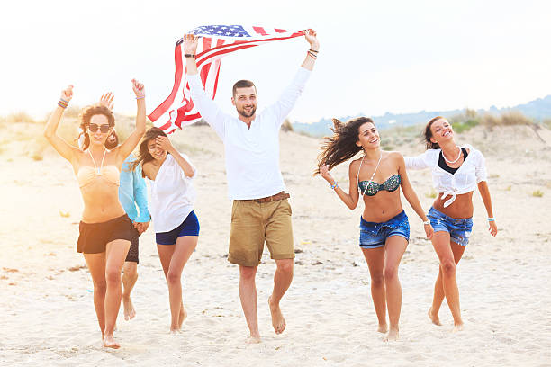 istock Friends celebrating on beach with USA flag 514277820