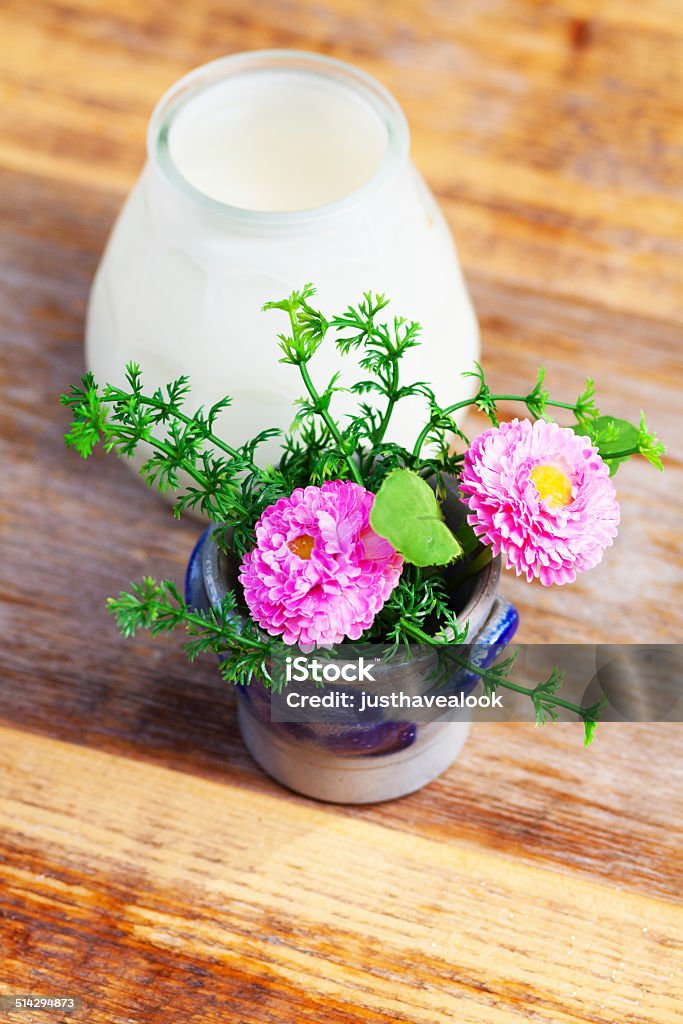 Artificial flower in wooden table Artificial flower in wooden table, pink colored, dahlia like. Artificial Stock Photo