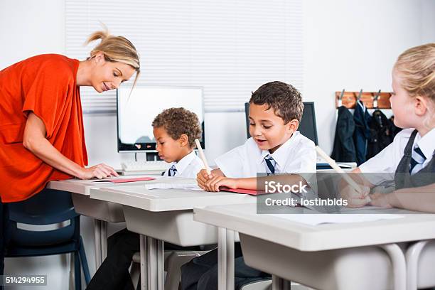 Teacher Helping Little Schoolboy With His Schoolwork In The Classroom Stock Photo - Download Image Now