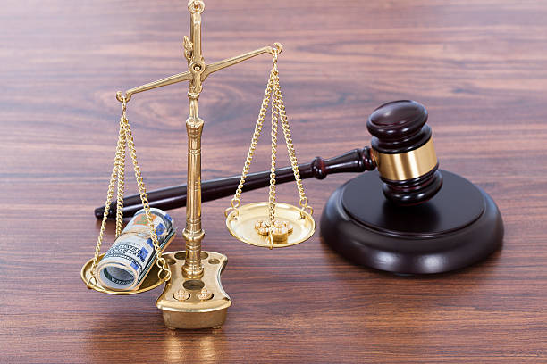 Gavel And Scales With Money On Desk Judge gavel and scales with money on wooden desk cost of legal malpractice stock pictures, royalty-free photos & images