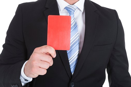 Midsection of young businessman showing red card over white background