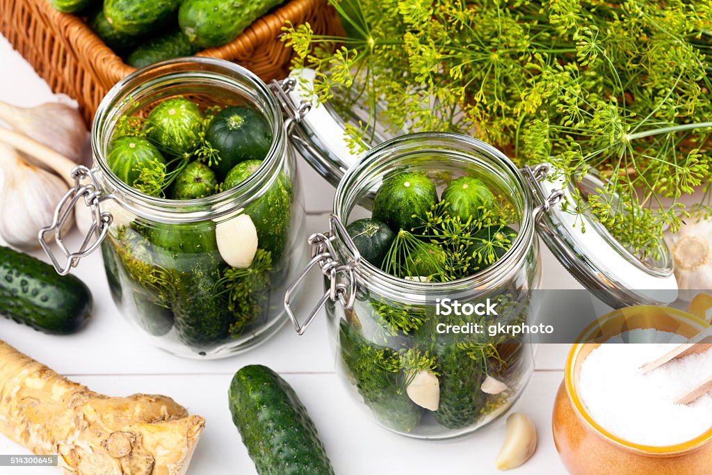 Homemade pickles in brine with garlic, dill and horseradish Homemade pickles in brine with garlic, dill and horseradish on woodboard Backgrounds Stock Photo