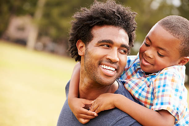 istock Father Giving Son Piggyback Ride In Park 514300679